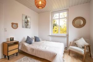 une chambre avec un lit, une fenêtre et une chaise dans l'établissement Altbauwohnung in Mayen im Grünen, à Mayen