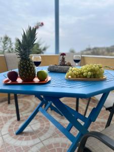 a blue table with two plates of fruit and wine glasses at Villa Bonita Private Traditional house in Kamari
