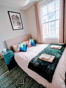 een slaapkamer met een groot bed met een raam bij Victoria's Bright Georgian Apartment in Liverpool