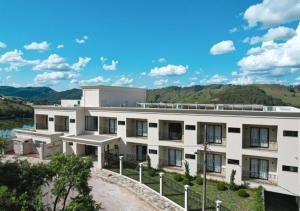 a white building with a hill in the background at Vista do Lago Hotel in Capitólio +82 photos