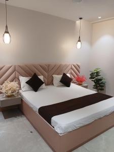 Una cama grande en un dormitorio con dos luces. en Ashirwad Lucknow, en Lucknow