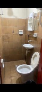 a bathroom with a toilet and a sink at Hotel Santo Antoninho in Goiânia