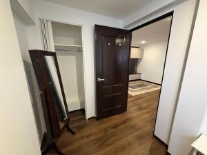 a hallway with a black door and a mirror at Self-Contained Studio in Loganholme