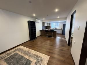 a large living room with a wooden floor and white walls at Self-Contained Studio in Loganholme