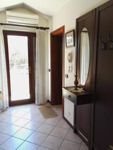 łazienka z umywalką, lustrem i drzwiami w obiekcie Pineta Spiaggia Grande w mieście SantʼAntìoco