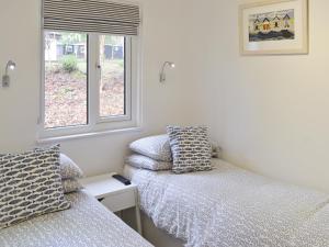 a bedroom with two beds and a window at Gracelands in Uny Lelant