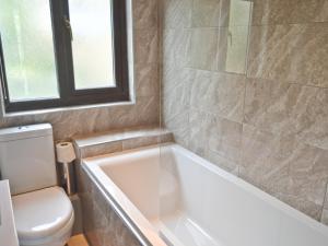 a bathroom with a tub and a toilet at Gracelands in Uny Lelant