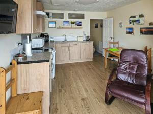 eine Küche mit einem Ledersessel und einem Tisch in der Unterkunft This 'N' That in Tintagel