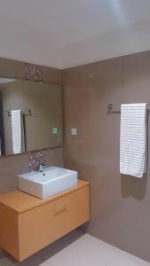 ein Badezimmer mit Waschbecken und Spiegel in der Unterkunft Uban Oasis in Accra