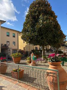 een hek met potten met bloemen en een boom bij Appartamento Magnolia in Mercatale Val Di Pesa