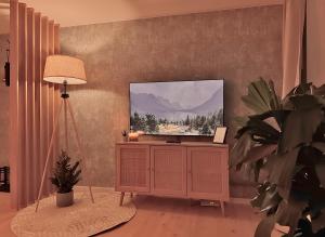 a living room with a flat screen tv on a cabinet at Gemütliche Fachwerkwohnung mit Hängematte, Elbnah 300m in Magdeburg