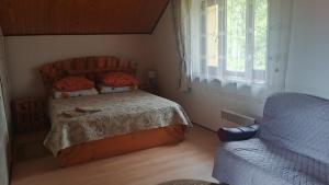a bedroom with a bed and a couch and a window at Під зорями in Slavske +11 photos