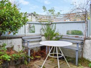 a table and a bench in a garden at Kestrel Cottage in Tavistock