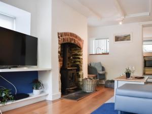 a living room with a fireplace and a tv at Kestrel Cottage in Tavistock +13 photos