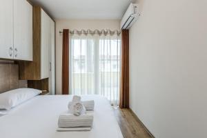 a bedroom with a white bed and a large window at Luma Penthouses by Kondo Stays in Tirana
