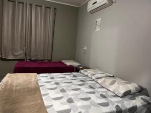 1 Schlafzimmer mit 2 Betten in einem Zimmer mit Fenster in der Unterkunft Residencial Gil in Foz do Iguaçu