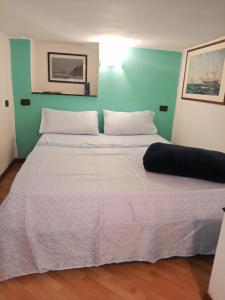a bed with two white pillows and a green wall at Angelo Home in Genova