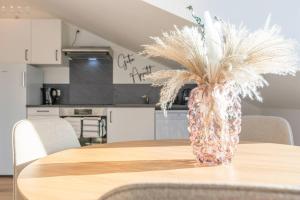 un vaso con piume su un tavolo in una cucina di Stylish, cozy and natural apartment a Mendig