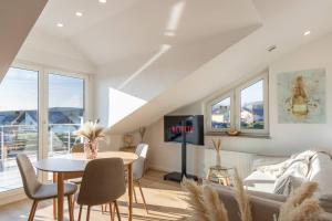un soggiorno con un tavolo e una TV di Stylish, cozy and natural apartment a Mendig