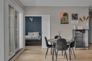 ein Esszimmer mit Tisch und Stühlen und einem Bett in der Unterkunft Northstay - Tromsø Harbor Mountain View Apartment in Tromsø + 16 Fotos