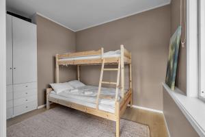 Etagenbett in einem Zimmer mit einer Leiter in der Unterkunft Northstay - Tromsø Harbor Mountain View Apartment in Tromsø