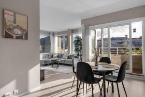 a living room with a table and chairs at Northstay - Tromsø Harbor Mountain View Apartment in Tromsø