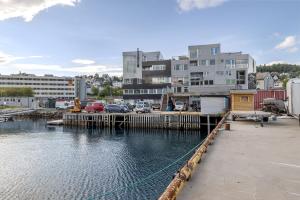 ein Jachthafen mit neben einigen Gebäuden geparkten Autos in der Unterkunft Northstay - Tromsø Harbor Mountain View Apartment in Tromsø