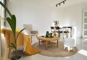 ein Wohnzimmer mit Couchtisch und Stühlen in der Unterkunft Modern 2-Bed Apt 80m2 with Elevator FREE Parking N19-25 in Paris