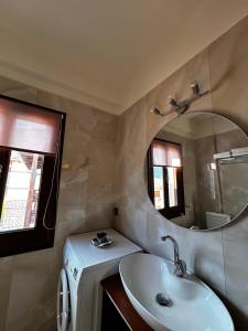 a bathroom with a sink and a mirror at MetsoVillas στο κέντρο του Μετσόβου in Metsovo