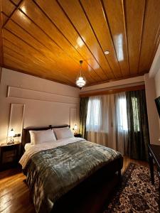 a bedroom with a large bed with a wooden ceiling at MetsoVillas στο κέντρο του Μετσόβου in Metsovo