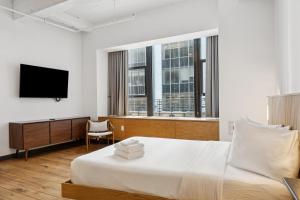 a hotel room with a bed and a television at Placemakr Wall Street in New York +207 photos