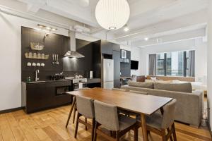 a kitchen and living room with a wooden table and chairs at Placemakr Wall Street in New York