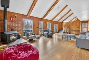 a living room with a fireplace and a brick wall at Huge Cabin w Hot Tub, Deck, Grill, Fire Pit, WiFi in Berkeley Springs