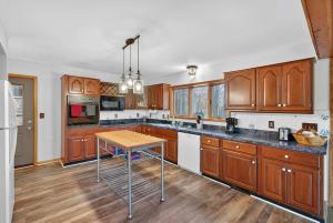 a kitchen with wooden cabinets and a wooden table at Huge Cabin w Hot Tub, Deck, Grill, Fire Pit, WiFi in Berkeley Springs