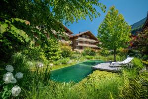 伊瑟尔特瓦尔德Chalet Apartments Iseltwald的花园内的游泳池,带房子