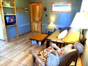 a room with a bed and a chair and a tv at Casa de Campo Meliquina in Lago Meliquina