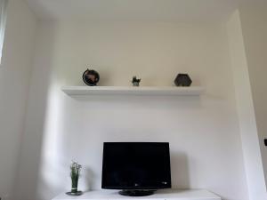 a flat screen tv sitting on top of a white wall at Vener Appartament - A due passi dal Lago in Ossuccio +12 photos