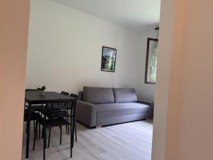 a living room with a couch and a table and chairs at Vener Appartament - A due passi dal Lago in Ossuccio