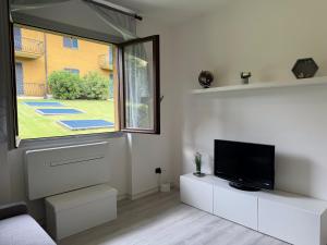 a living room with a tv and a window at Vener Appartament - A due passi dal Lago in Ossuccio