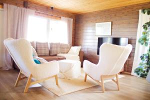 a living room with white chairs and a television at Private Villa At Lake 