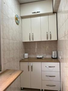 巴统Tamara的配有白色橱柜和木桌的厨房