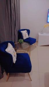 zwei blaue Stühle und ein Tisch in einem Badezimmer in der Unterkunft Uban Oasis in Accra