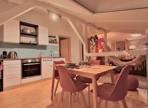 a kitchen with a wooden table and chairs at Gemütliche Fachwerkwohnung mit Hängematte, Elbnah 300m in Magdeburg