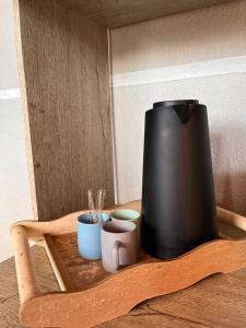 Eine schwarze Kaffeekanne steht auf einem Holztisch in der Unterkunft Residencial Gil in Foz do Iguaçu