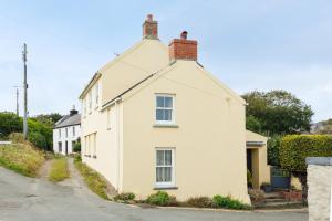a white house on the side of a street at Charming Upper Solva Cottage by Beaches and Harbour in Solva