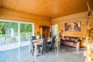 a dining room with a table and chairs and a couch at Castle view terrace - Swimming pool - Air conditioning in La Vancelle +9 photos