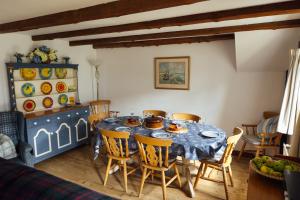 a dining room with a blue table and chairs at Charming Upper Solva Cottage by Beaches and Harbour in Solva