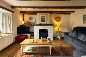a living room with a couch and a fireplace at Charming Upper Solva Cottage by Beaches and Harbour in Solva