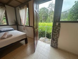 una camera con letto e vista su un campo di Green Forest Uvita River a Uvita