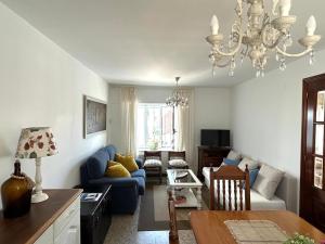 a living room with a blue couch and a chandelier at Casa Pancha in Ribadeo